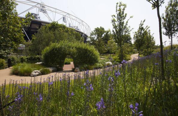 A view of the Great British Gardens with archway of plants and view of London Stadium