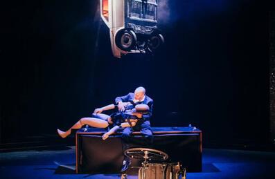 A stage performance with a person and a large puppet