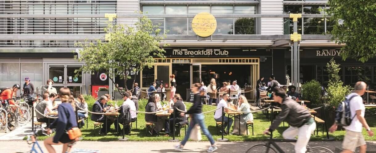 people on beer garden benches socialising in the sun