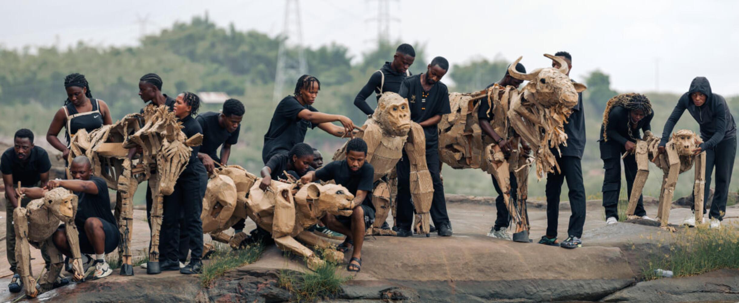 A group of people holding life sized animal puppets
