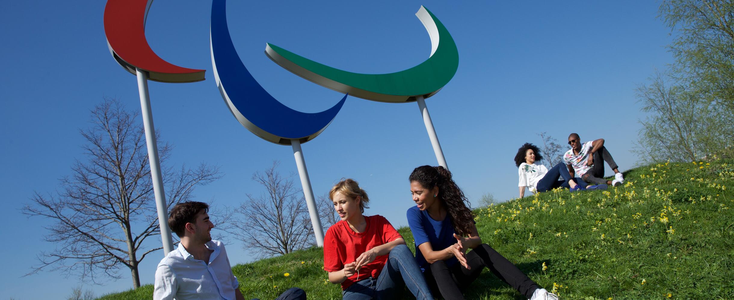 People sitting in front of the Paralympics symbol