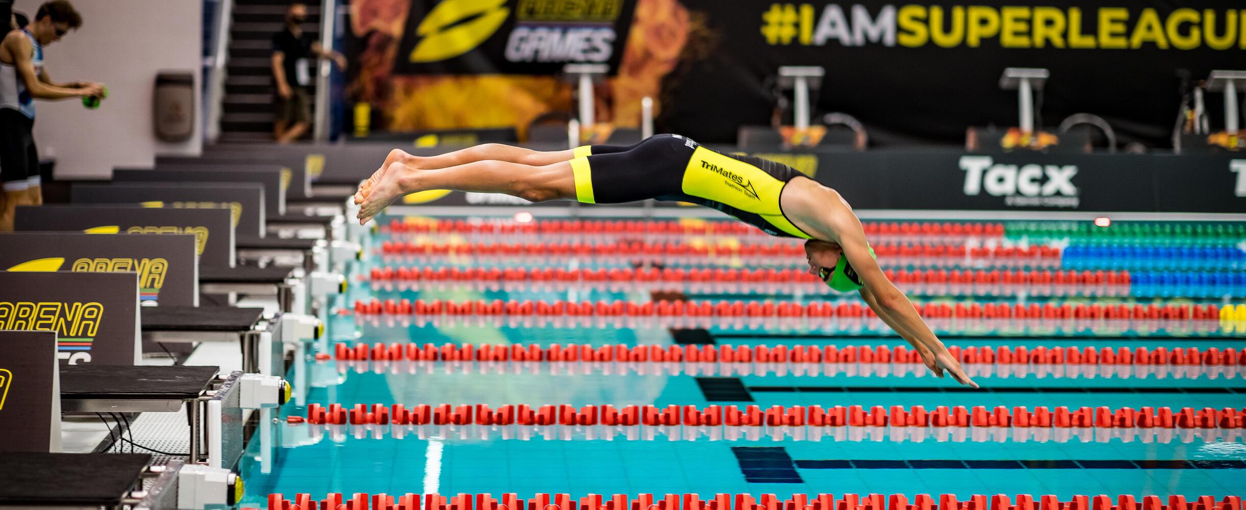 Athlete diving off the starting blocks into a pool