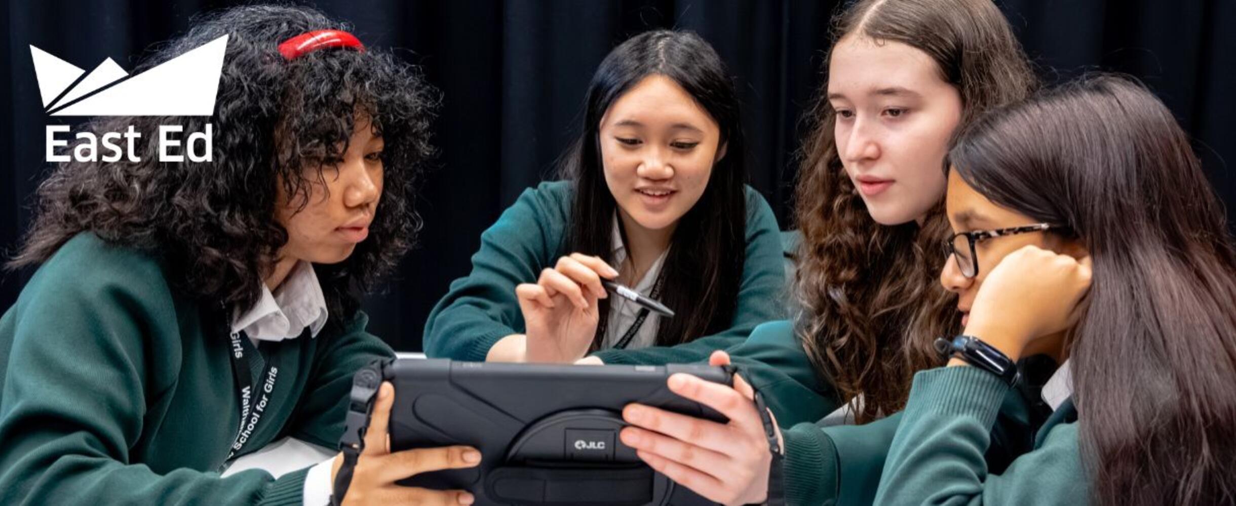 Young people gather round an ipad
