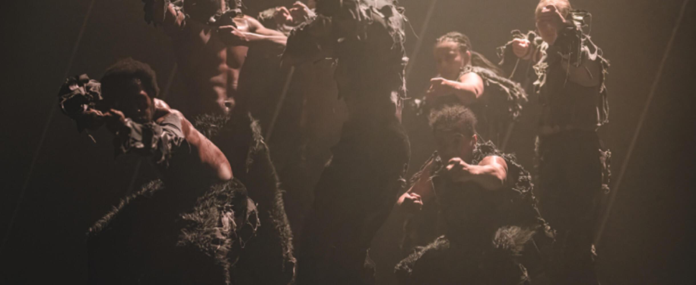 Six dancers performing in Until We Sleep on a dimly lit stage