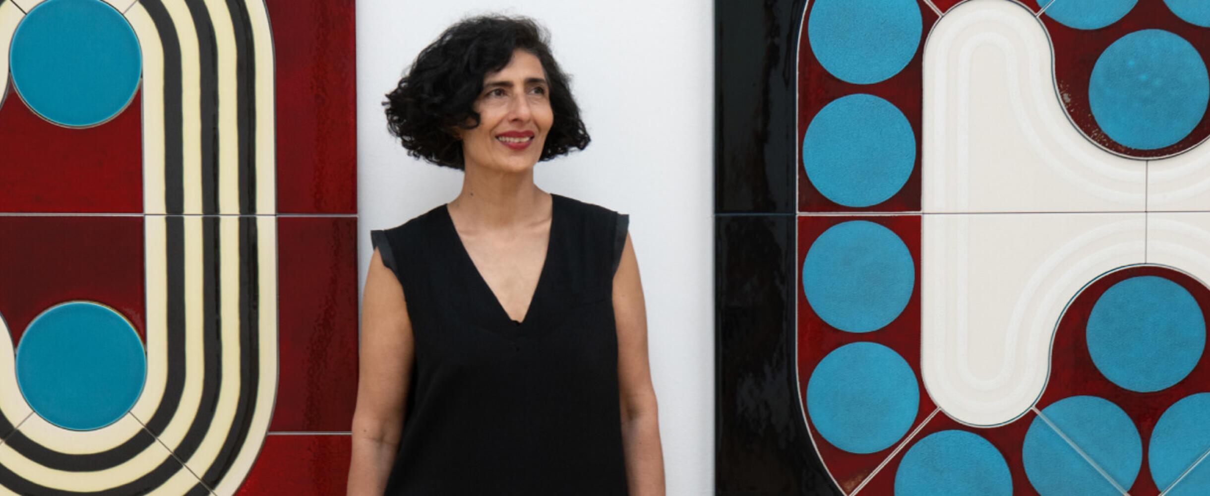 Artist Lubna Chowdhary stood in front of artwork