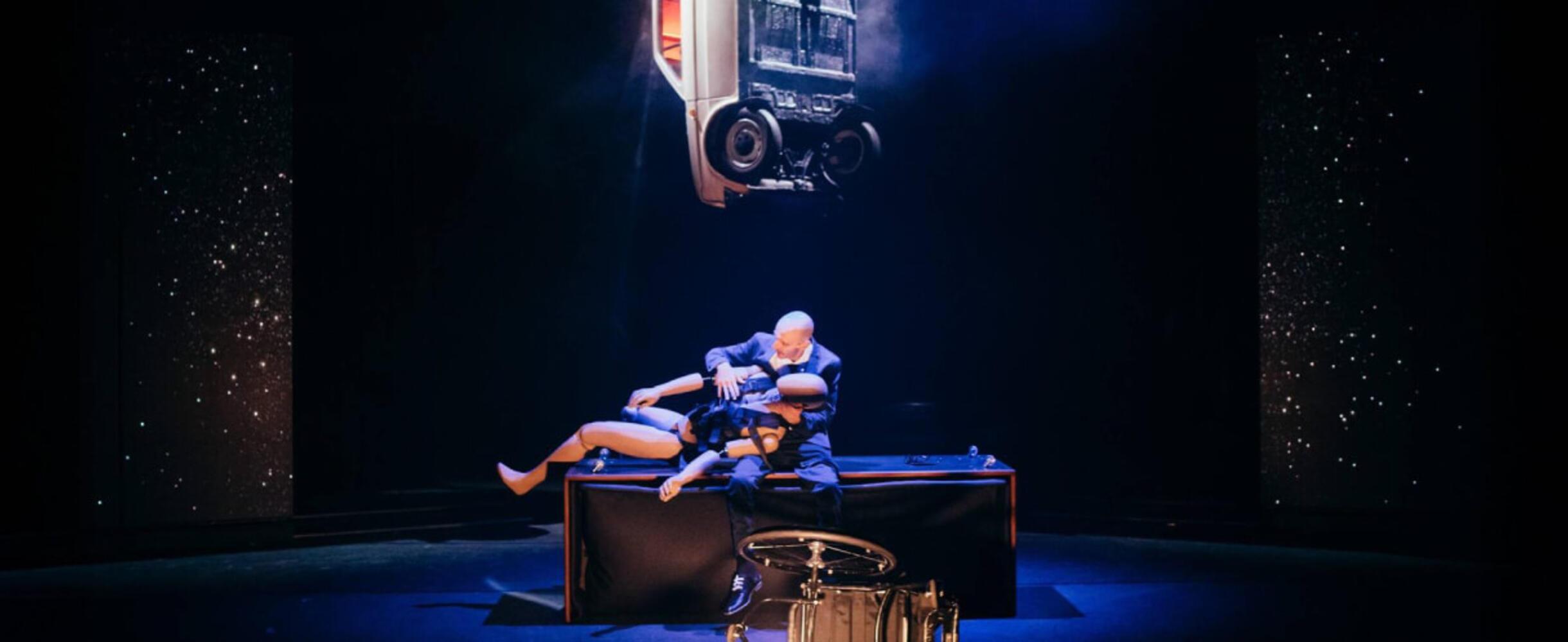 A stage performance with a person and a large puppet
