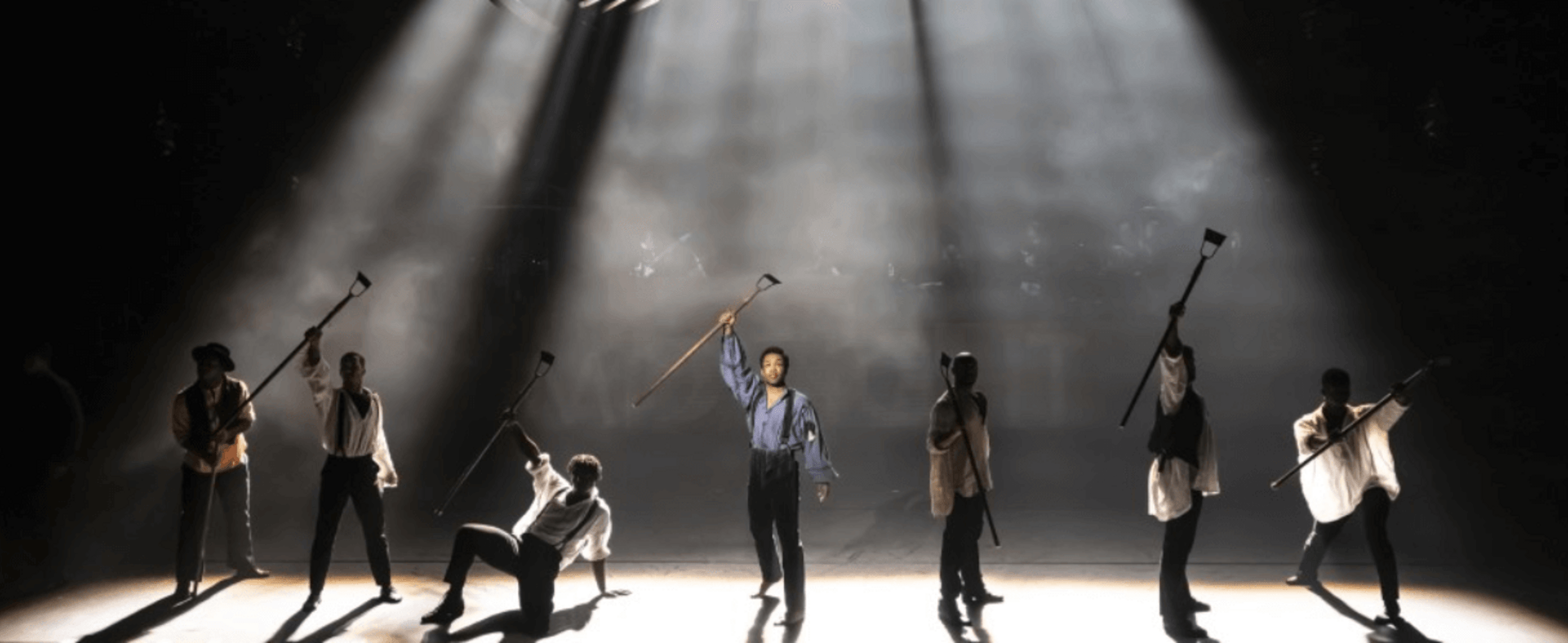 Performers on stage raise their hands aloft