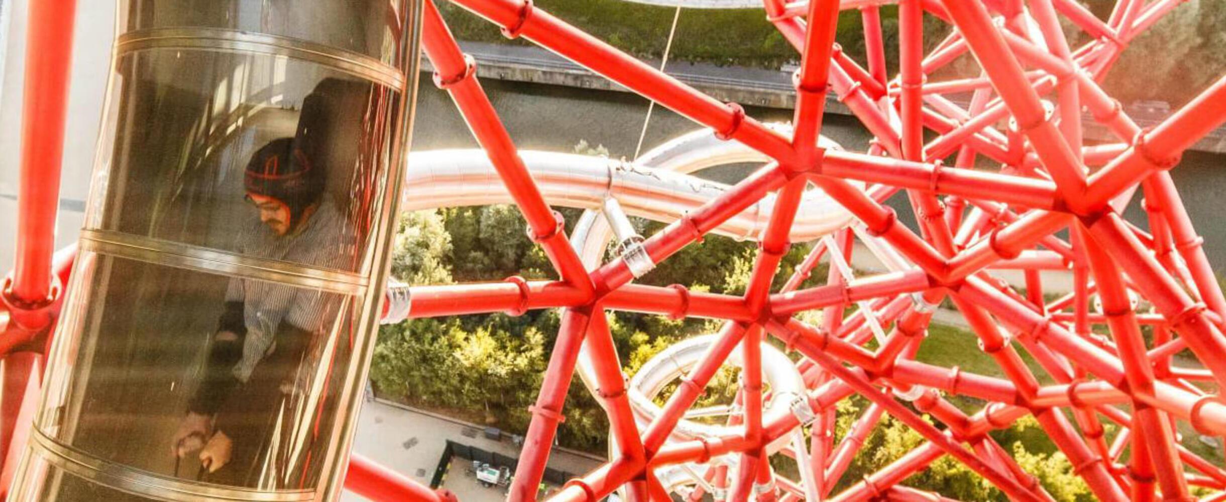 A close up view of a person going down the slide portion of the Arcelormittal Orbit slide