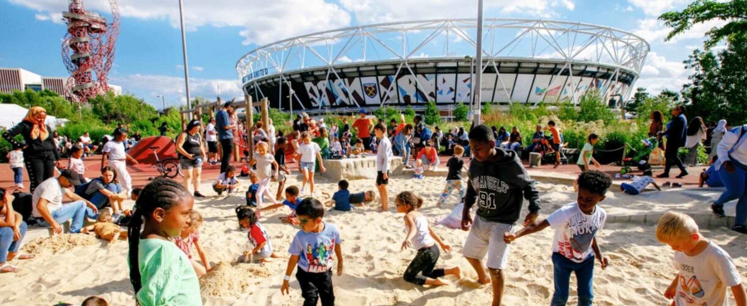 Kids playing in the sand in front of the Stadium