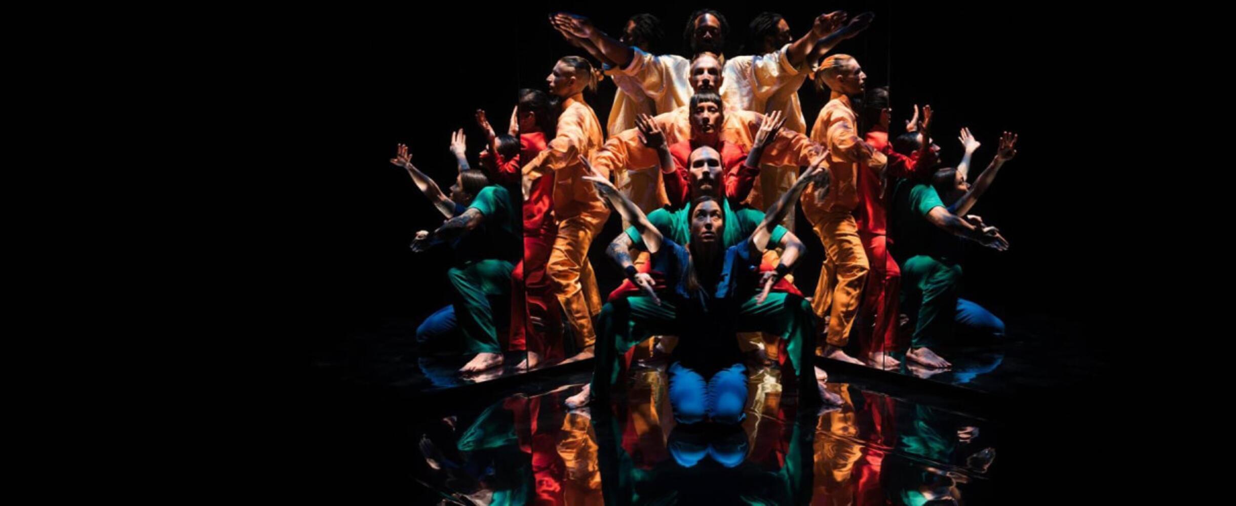 A group of people on stage with interlocked arms