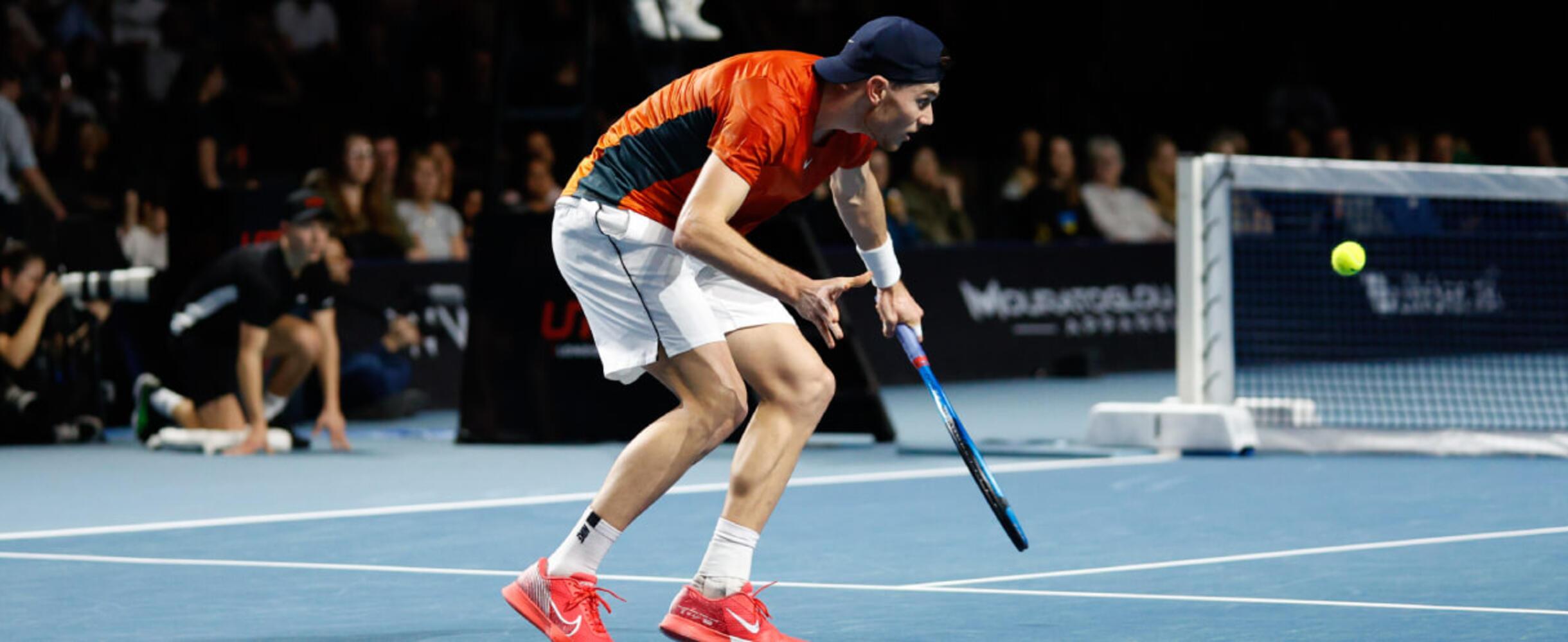 A tennis player plays a shot