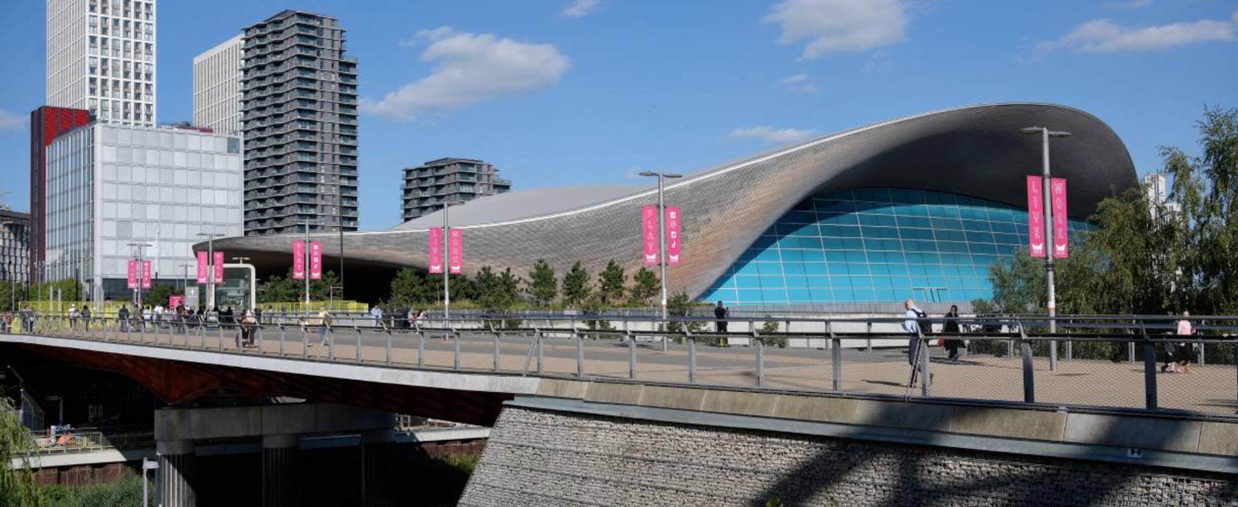 A photo of the exterior of the London Aquatics Centre on a sunny day