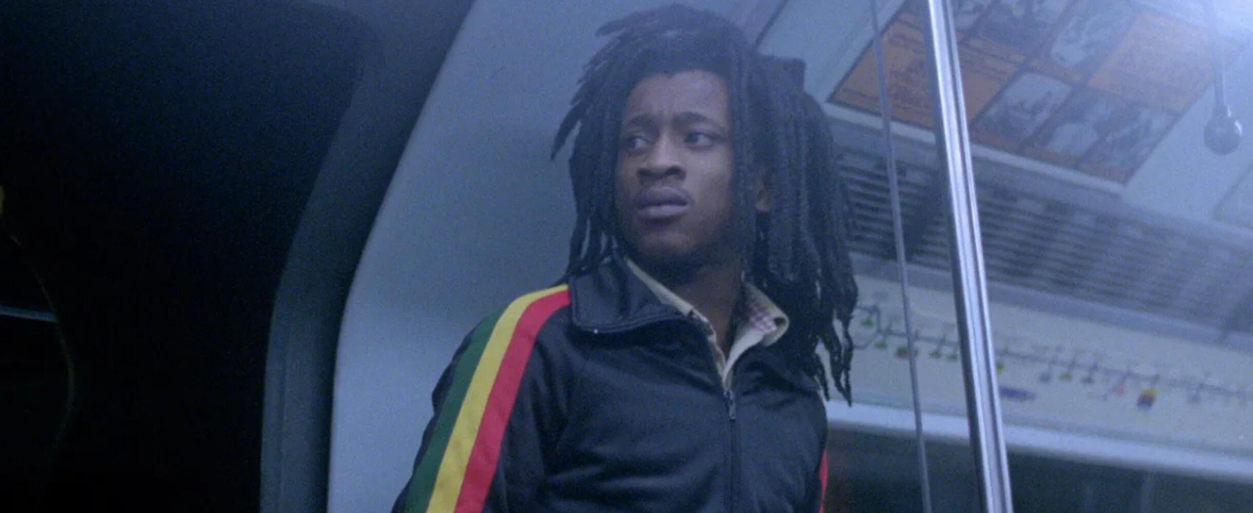 A man with dreadlocks stands on the tube
