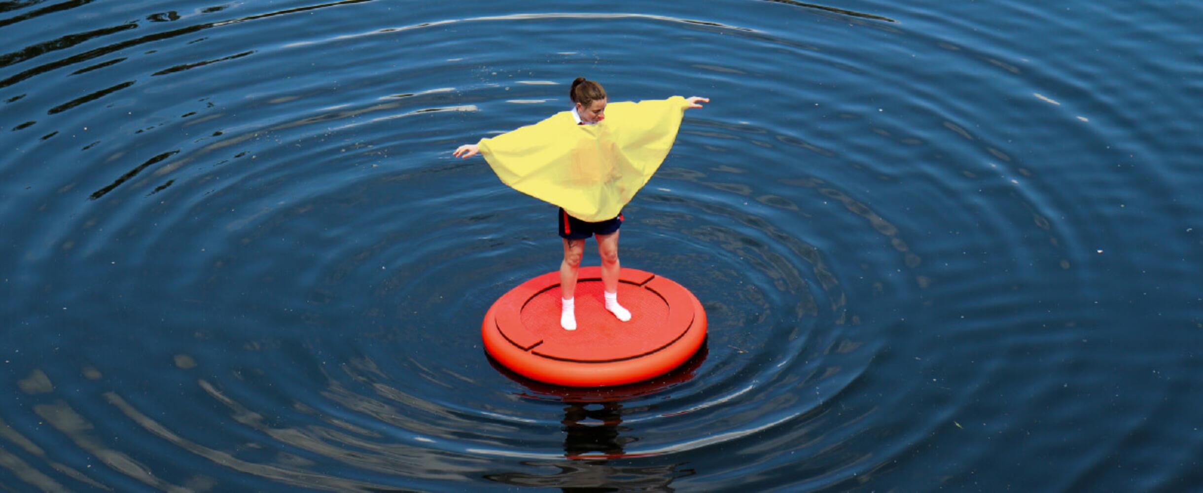 A participant of Discosailing stands on a float on water