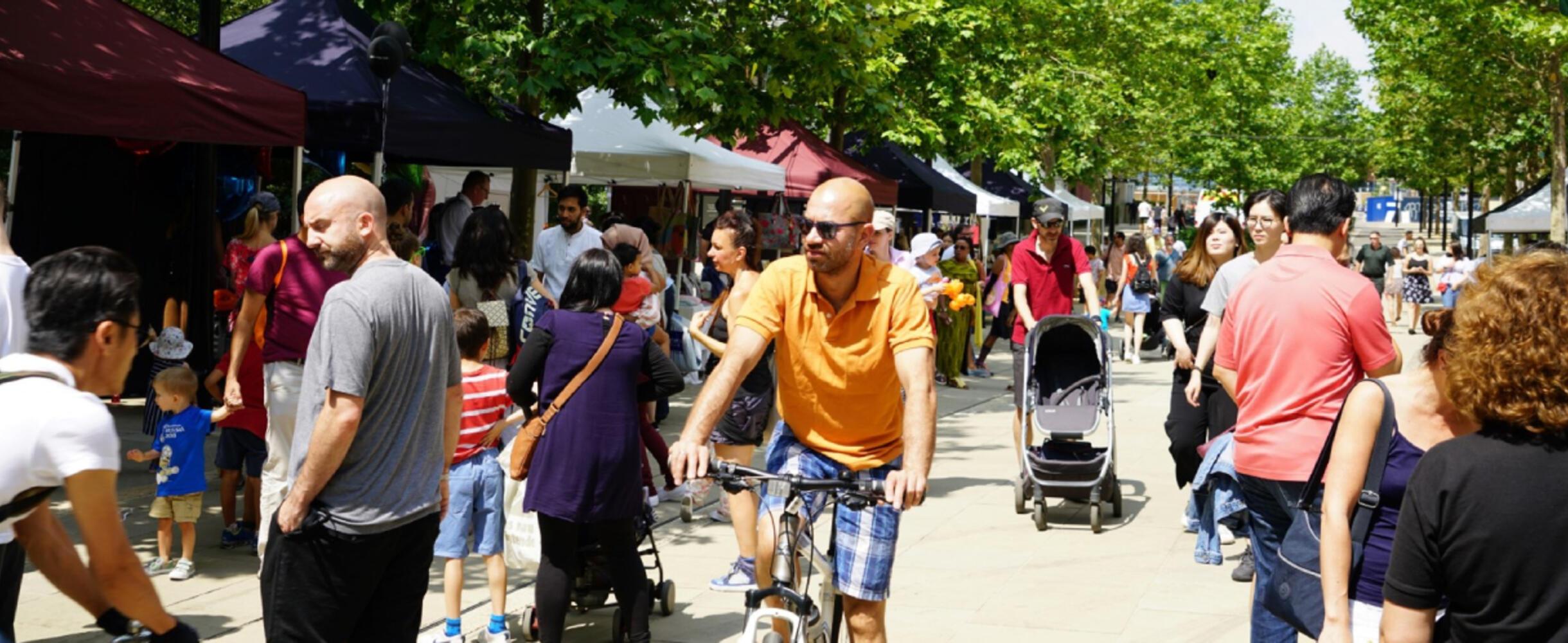 A crowd of people walk through a street food festival