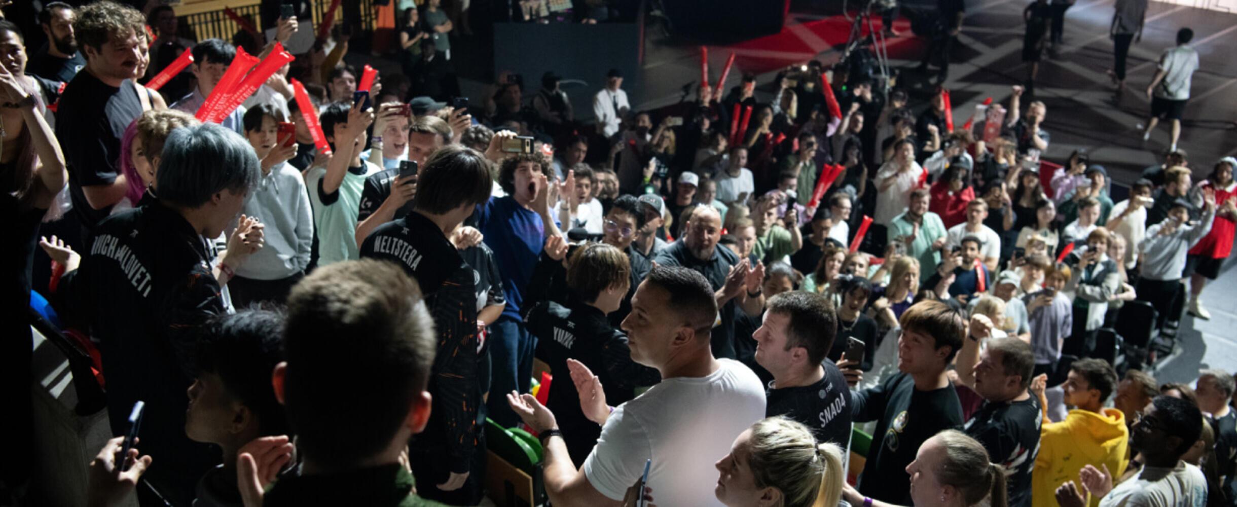 A crowd cheers as a esports gaming team arrives