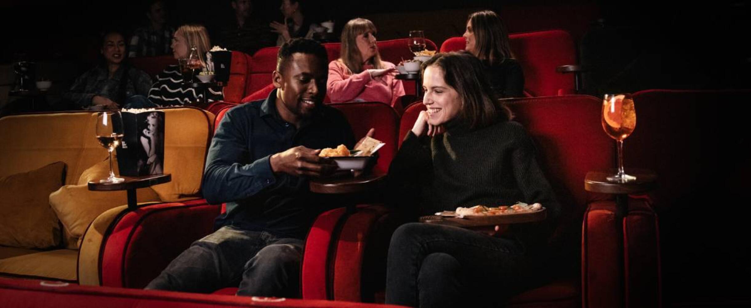 People sat at Every Cinema Stratford International eating food and watching a film
