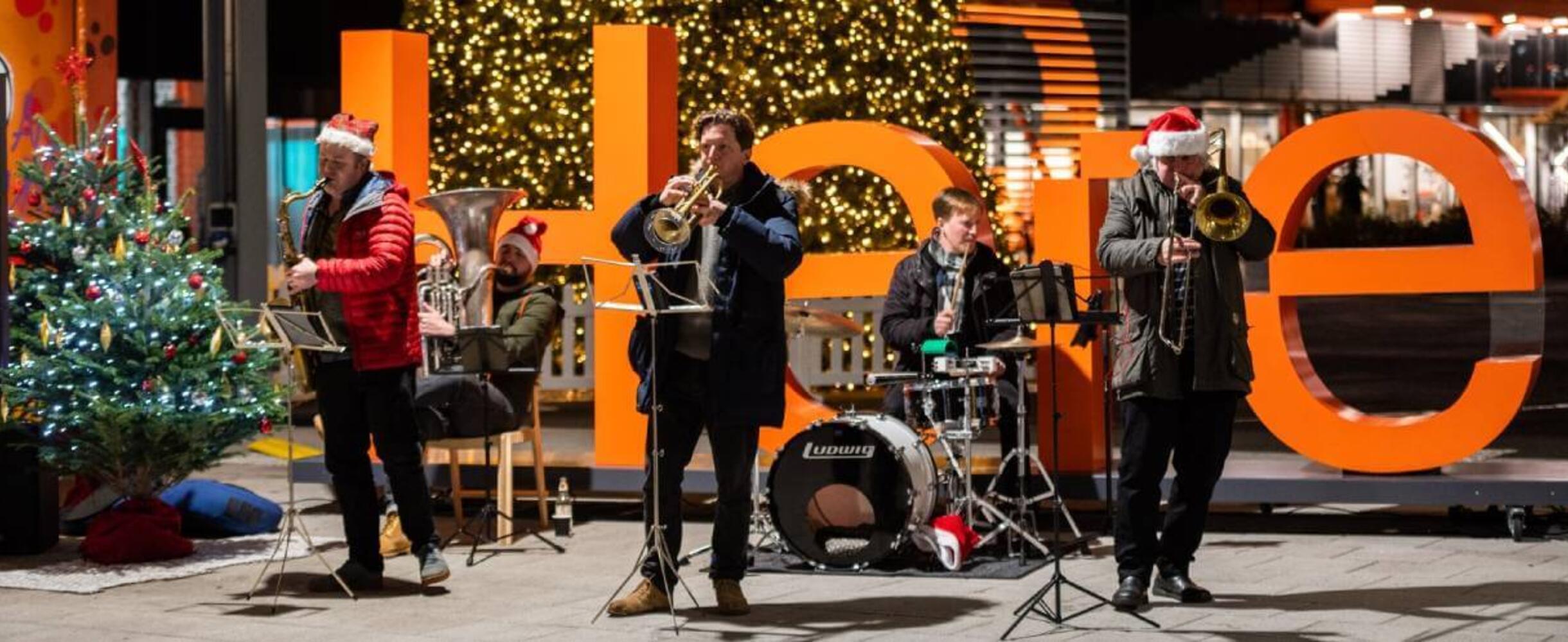 A band plays on stage at Here East canalside Christmas event