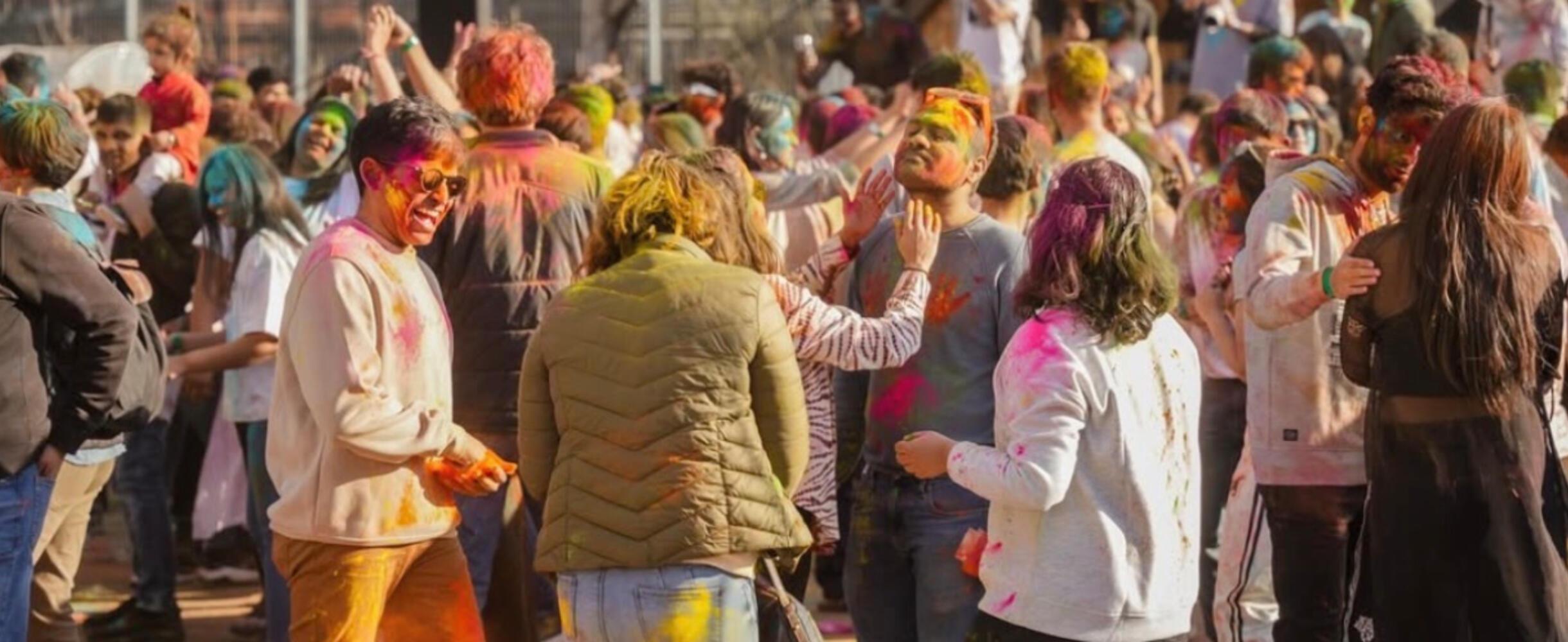People celebrate Holi with bright colours on their faces