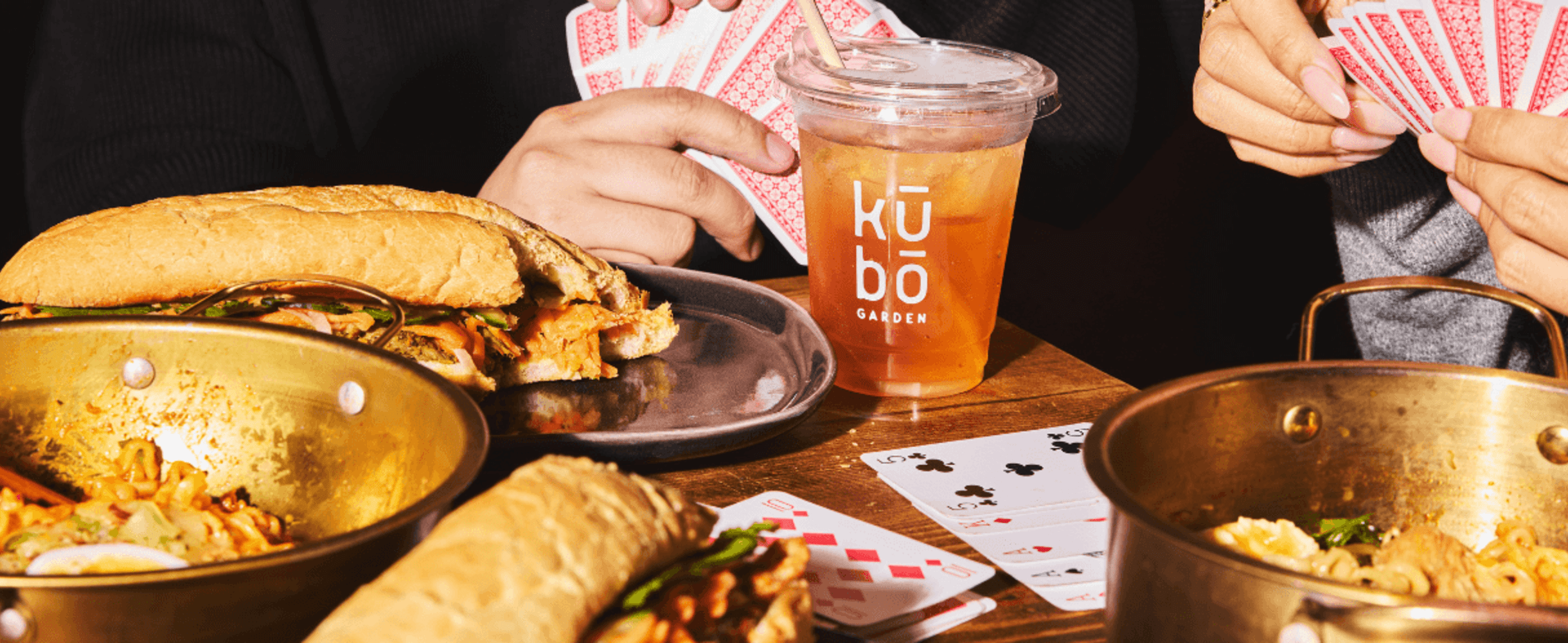 People playing cards whilst eating and drinking