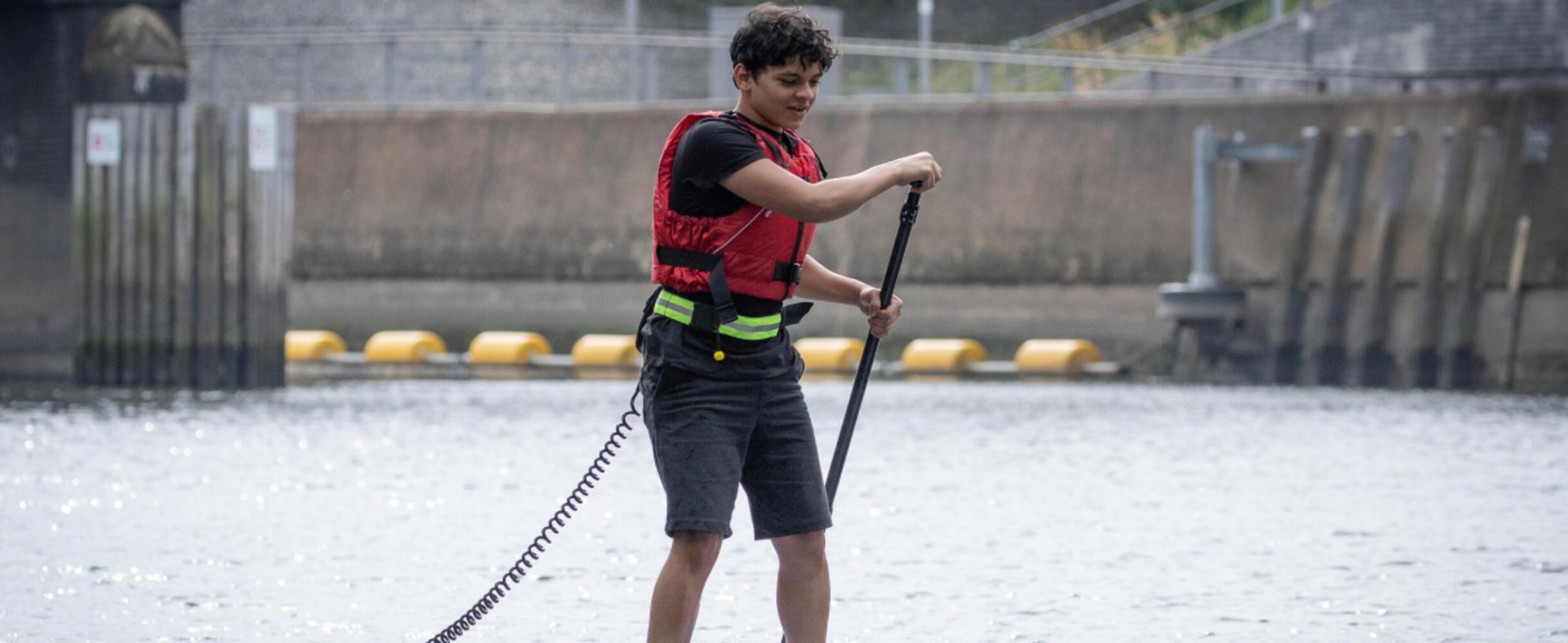 A young adult on a paddle board