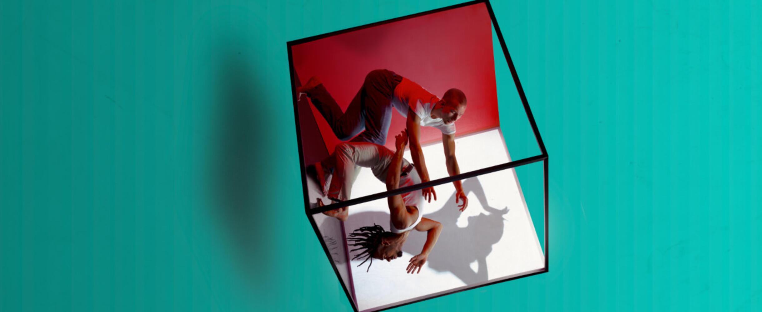 A conceptual image of two men dancing within a rotating cube.