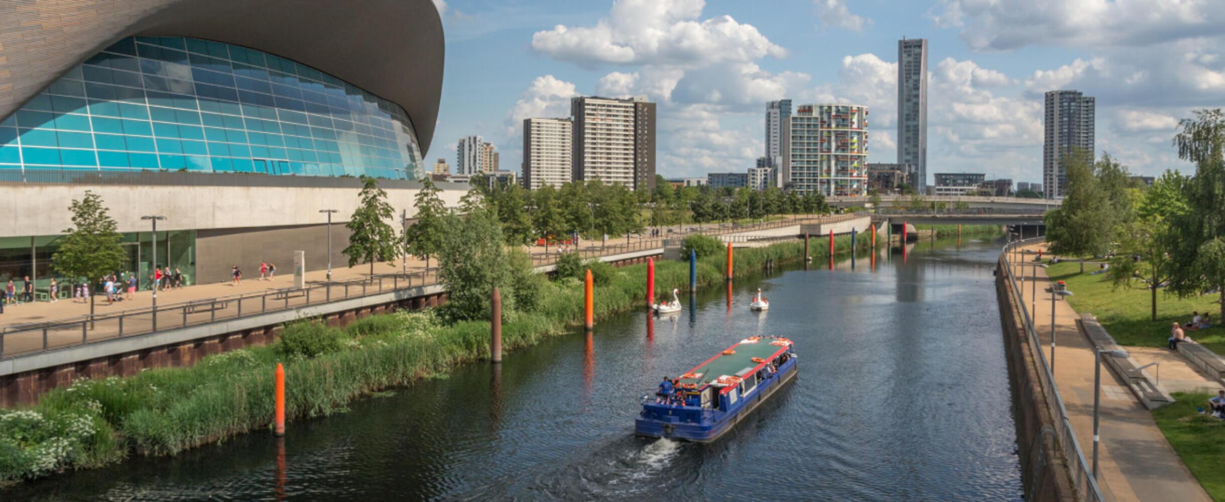 A boat tour travels down river by the London Aquatic Centre