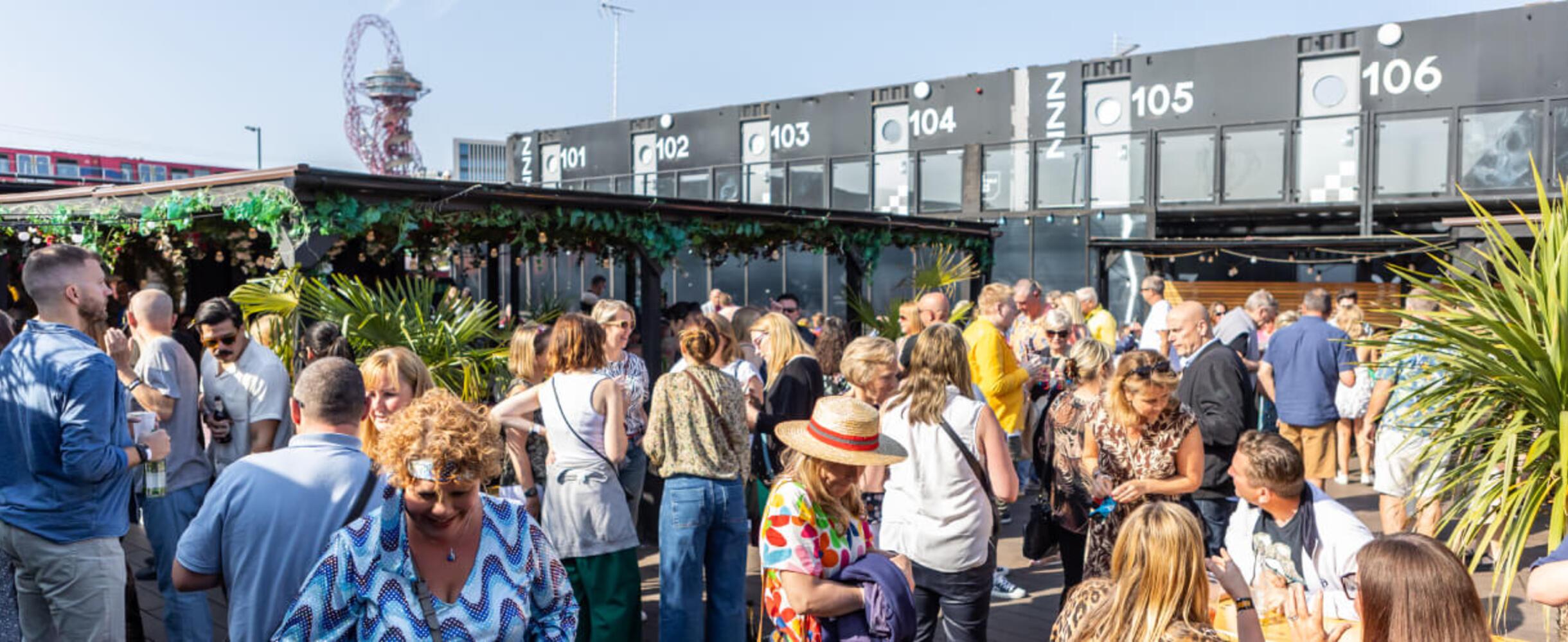 A group of people on the terrace of Snoozebox with the hotel in the background