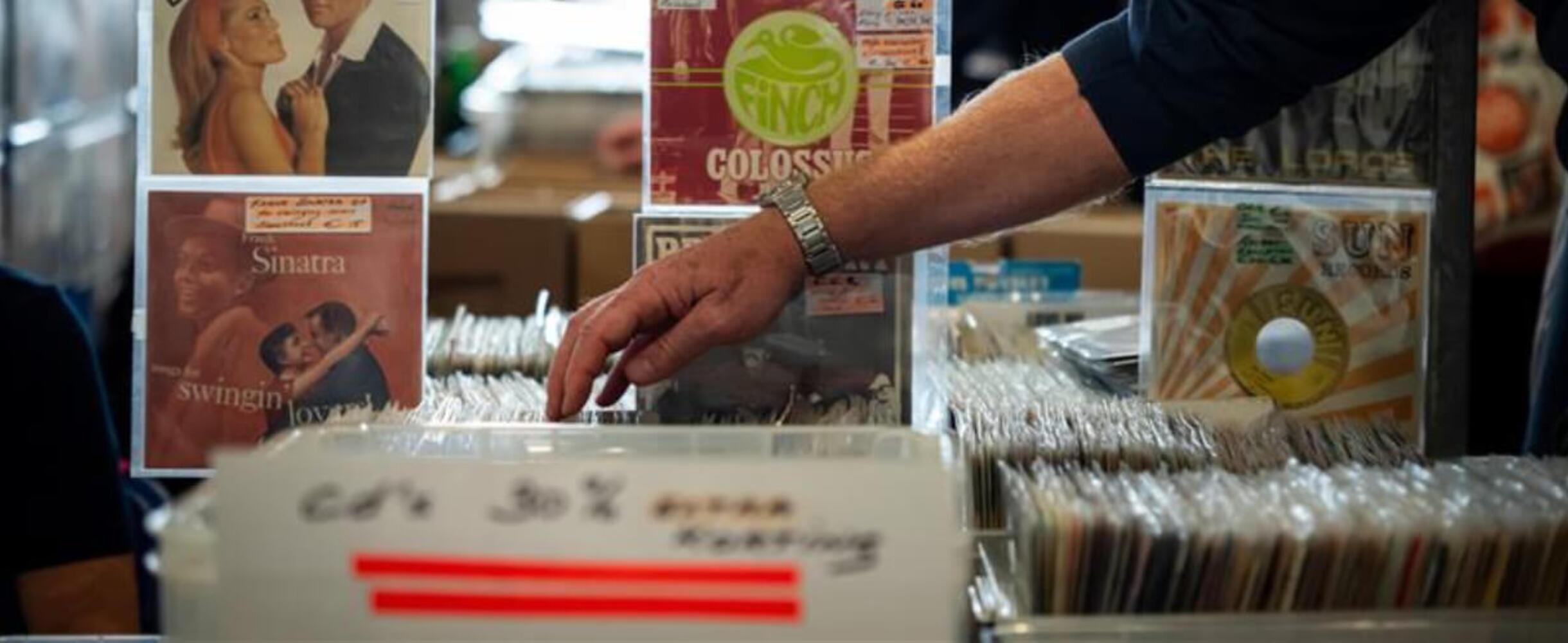 someone reaches into a box of records