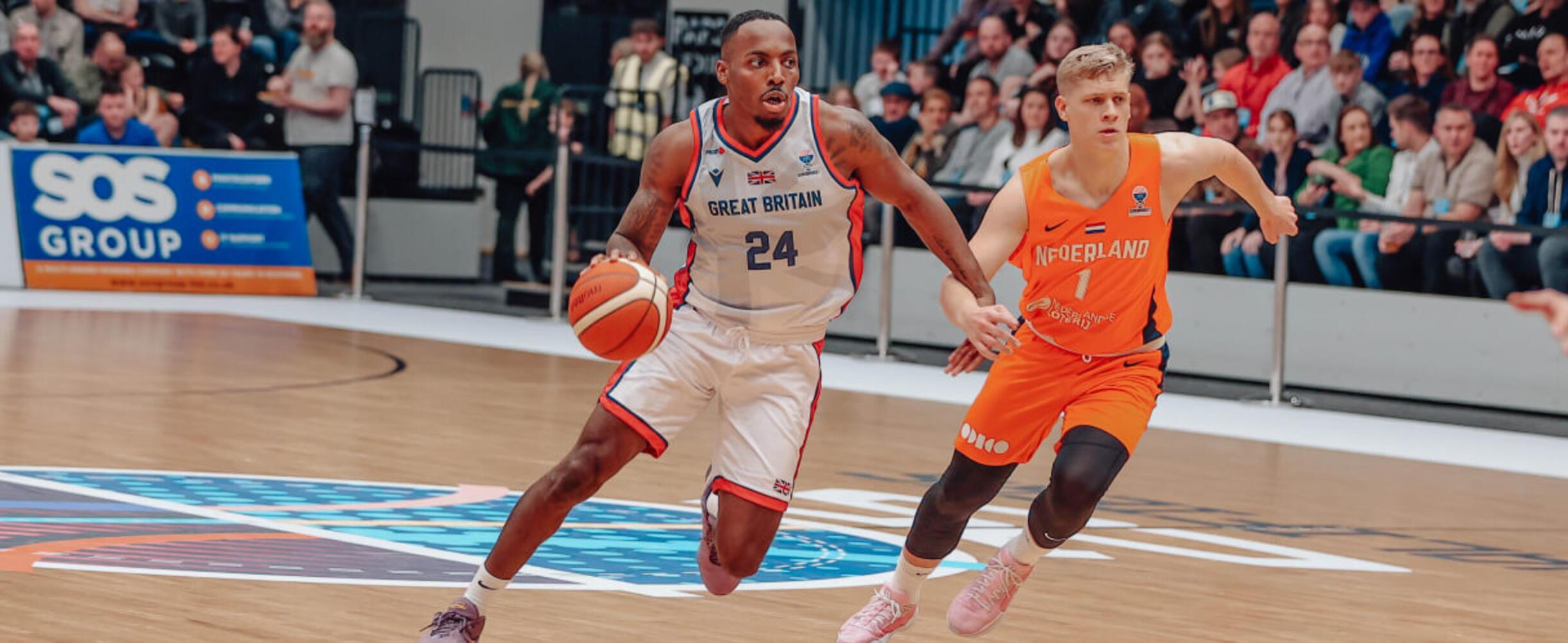 A GB Basketball player moves with the ball past an opposition player
