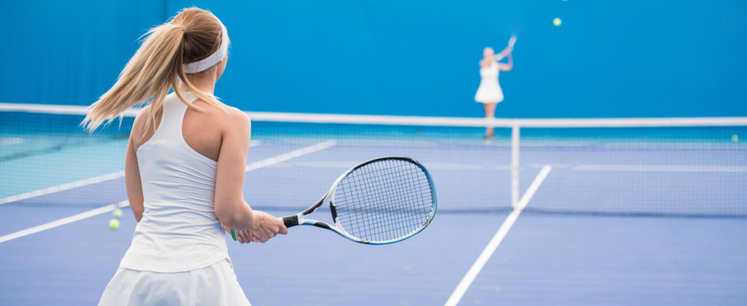 A tennis player readies herself to return a ball