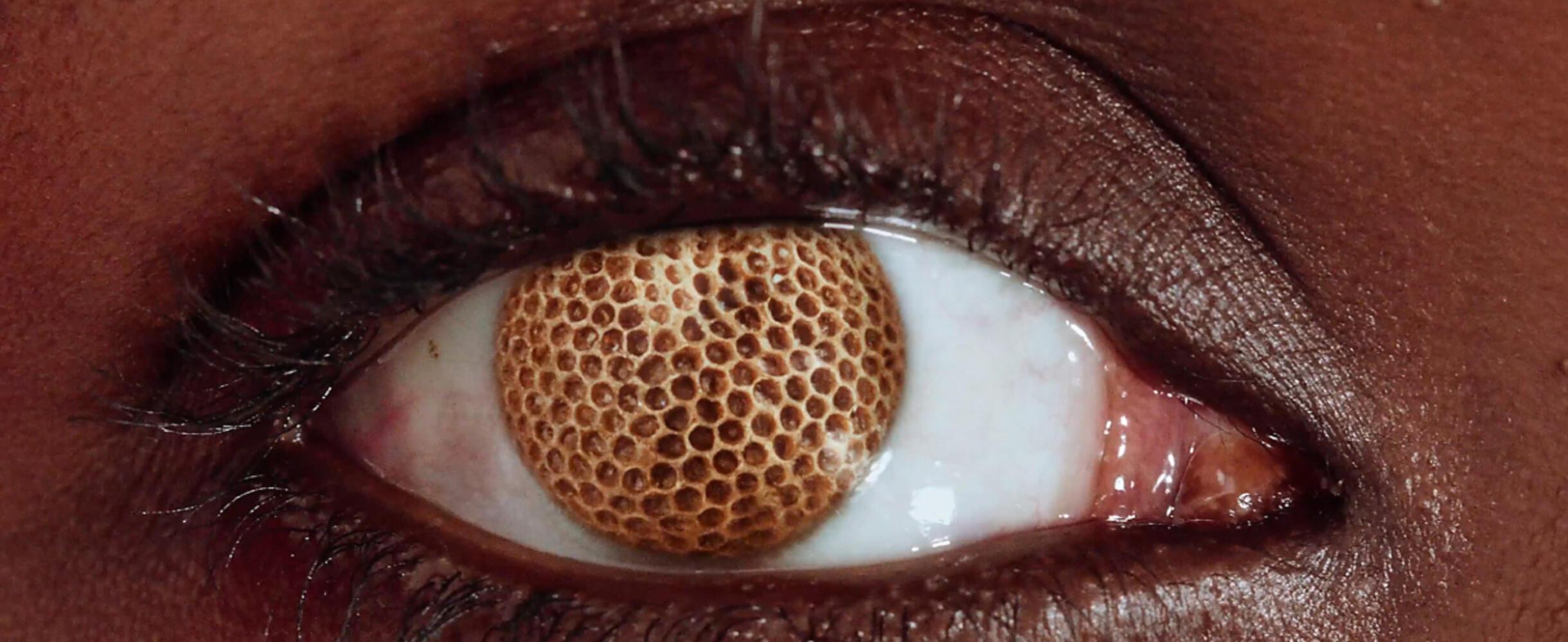 A close up of an eye with a honeycomb centre