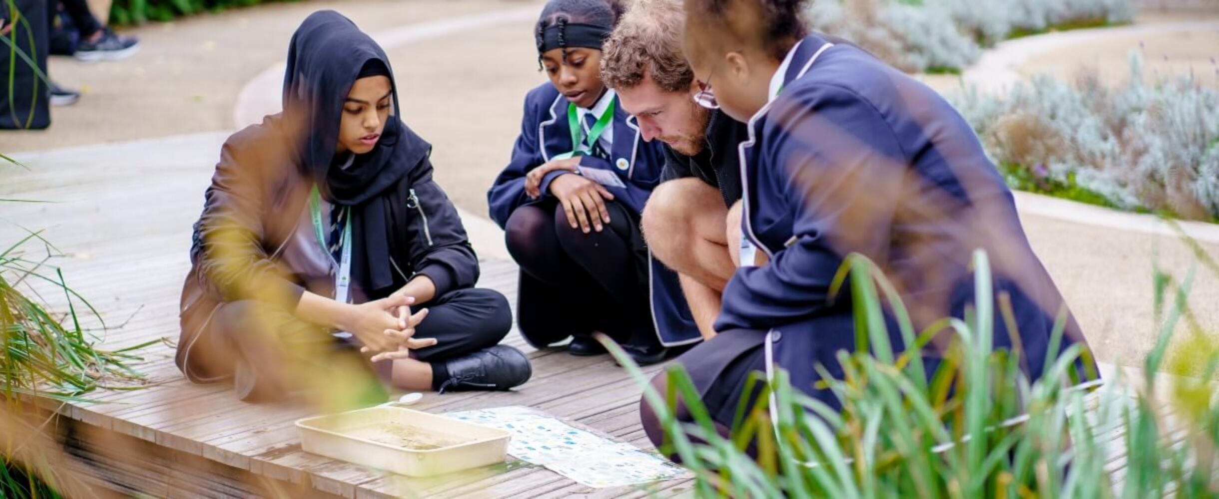 A group of school girls and their teacher going over school work
