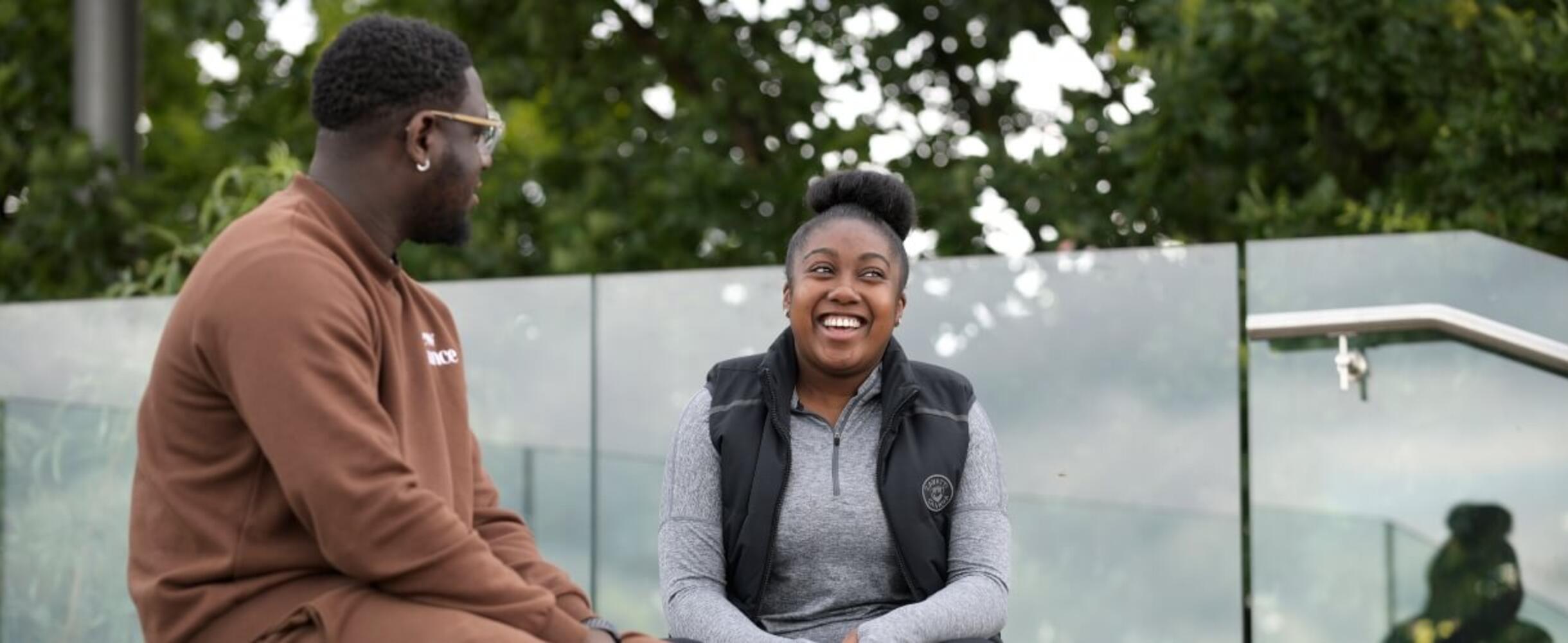 A pair of people outside in the Park chatting