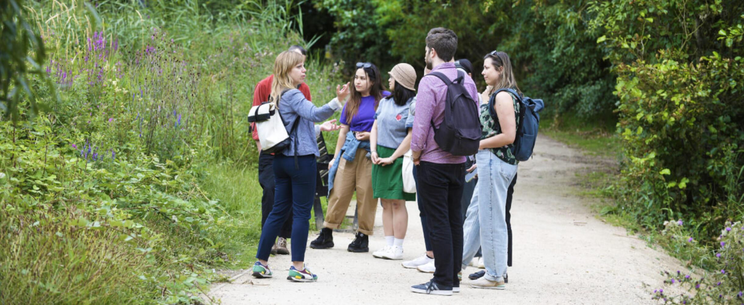 A group of people take a tour through the Queen Elizabeth Olympic Park