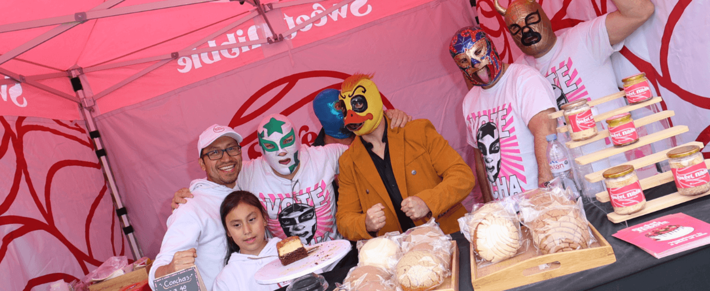 Masked people pose for a photo in a food stall