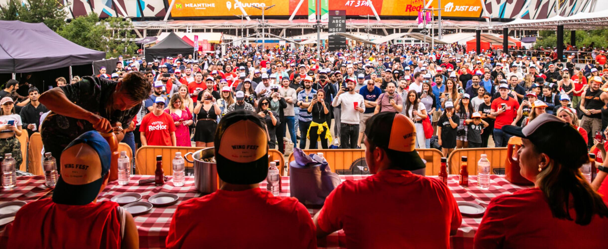 A crowd at Wing Fest with people on stage