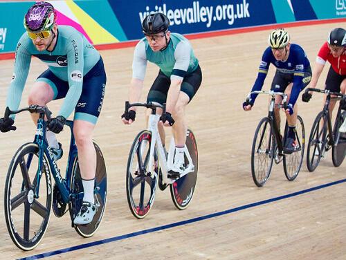 Four cyclists in a line ride round the Velodrome