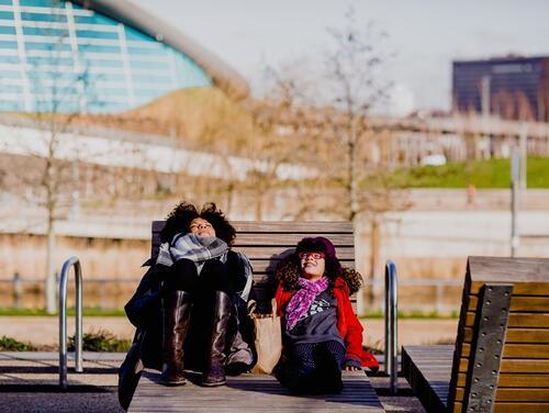 Mum and daughter sitting in chair outside