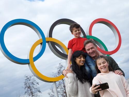 Family taking selfie in front of Olympic rings