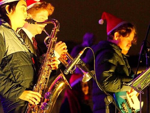 A band plays on stage in santa hats