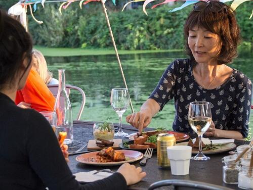 Two people dining by the canal in Barge East