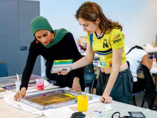 Two people working at a bench at East Summer School