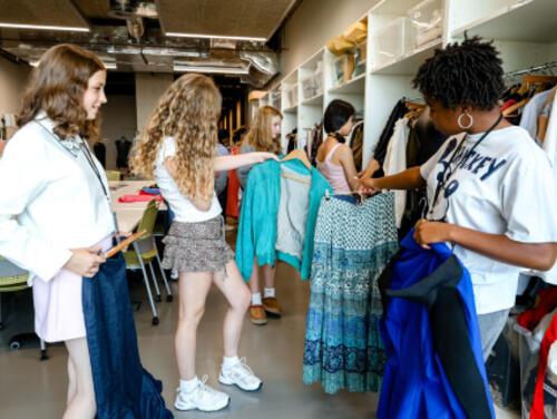 A group of teenagers look at clothes at East Summer School