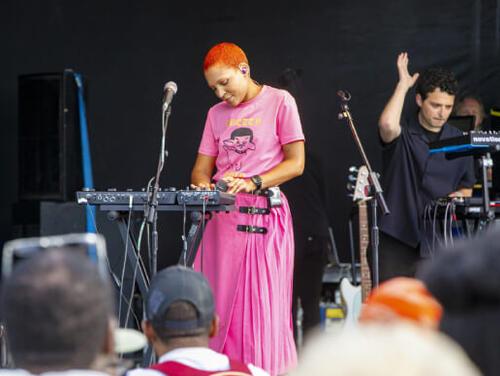 a singer wearing pink performs at the Great Get Together