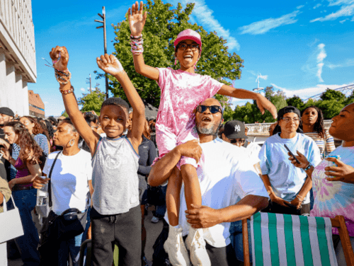 A family in a crowd at an outdoor music festival