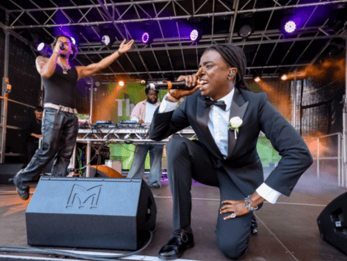 A singer in a tuxedo performs with his band