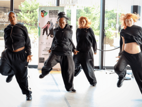 Four dancers in black perform