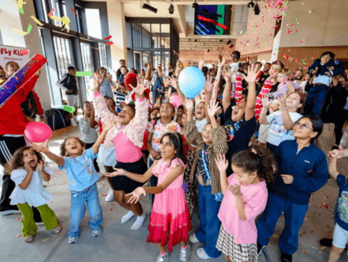 A crowd of children underneath falling confetti