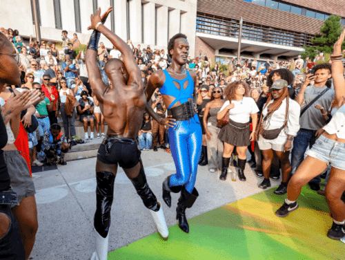 Two people dance in the middle of a crowd